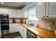 Well-equipped kitchen featuring stainless steel appliances, white cabinetry, butcher block countertops, and lots of natural light at 1137 Dickson Ave, Hanahan, SC 29410