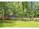 A spacious backyard with a shed, surrounded by a wooden fence and lush trees at 114 Heritage St, Summerville, SC 29485