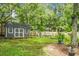View of a spacious backyard with a shed and a small playground surrounded by lush trees at 114 Heritage St, Summerville, SC 29485