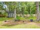 View of a spacious backyard with a shed and a small playground surrounded by lush trees at 114 Heritage St, Summerville, SC 29485