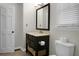 Bathroom featuring a dark vanity, framed mirror, and a toilet with a storage basket at 114 Heritage St, Summerville, SC 29485