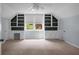 Bright bedroom with built-in shelving, cabinets, desk area, ceiling fan, and a window overlooking the exterior at 114 Heritage St, Summerville, SC 29485