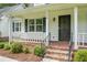 Charming front porch with brick flooring, white railings, and a beautifully landscaped yard at 114 Heritage St, Summerville, SC 29485