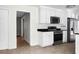 Well-lit kitchen with white cabinets, stainless steel appliances, and black countertops at 114 Heritage St, Summerville, SC 29485
