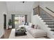 Bright living room featuring hardwood floors, a staircase, and a large window with gray curtains and furniture at 114 Heritage St, Summerville, SC 29485