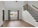 Bright living room featuring hardwood floors, a staircase, and a large window with gray curtains at 114 Heritage St, Summerville, SC 29485