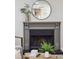 Close up of a stylish fireplace with gray mantle, decorative mirror, and contemporary accents at 1161 Monaco Dr, Mount Pleasant, SC 29464