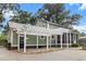 Exterior view of a home with a charming pergola, screened porch, and well-manicured landscaping at 1211 Dennis Blvd, Moncks Corner, SC 29461