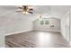 Large bonus room with wood laminate flooring, wood paneled walls, ceiling fans, and natural light at 1211 Dennis Blvd, Moncks Corner, SC 29461