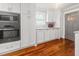 Modern kitchen showcasing stainless steel appliances, white cabinets, and warm-toned hardwood flooring at 1211 Dennis Blvd, Moncks Corner, SC 29461