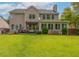 Spacious backyard with a large two-story home, patio area, sunroom, and beautifully maintained lawn at 125 Spring Meadows Dr, Summerville, SC 29485