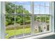 Scenic backyard view with lush greenery, serene pond, and charming shed, visible through a large window at 125 Spring Meadows Dr, Summerville, SC 29485