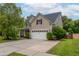 Inviting two-story home featuring a manicured lawn, attached two-car garage, and lush landscaping at 125 Spring Meadows Dr, Summerville, SC 29485