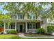 Beautiful front porch with white columns and railings, offering a cozy outdoor space with lush landscaping at 125 Spring Meadows Dr, Summerville, SC 29485