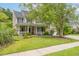 Charming two-story home with a welcoming front porch, mature trees, and well-maintained lawn at 125 Spring Meadows Dr, Summerville, SC 29485