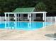 Exterior view of a community pool featuring a green roof gazebo and surrounding lush trees at 125 Spring Meadows Dr, Summerville, SC 29485
