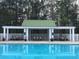 Community pool featuring a covered seating area, white fencing, and lush surrounding trees at 125 Spring Meadows Dr, Summerville, SC 29485