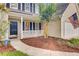 Close-up of home's front door and yard, showing mulch bed, porch, and American flag at 1253 Horseshoe Bnd, Mount Pleasant, SC 29464