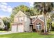 Two-story home with brick accents, red shutters, palm tree, and a lush green lawn at 126 Thousand Oaks Cir, Goose Creek, SC 29445