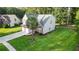 Aerial view of a home with gray siding, brick accents, a palm tree, and a large green lawn at 126 Thousand Oaks Cir, Goose Creek, SC 29445