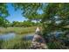 Scenic view of a private wooden dock extending into a tranquil marsh waterway with lush vegetation at 130 Chadwick Dr Dr, Charleston, SC 29407