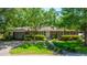 Charming brick home with a well-manicured lawn, mature trees, and a paved driveway and carport at 130 Chadwick Dr Dr, Charleston, SC 29407