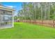 View of the grassy backyard surrounded by a wood fence and featuring a screened in porch at 1350 Wild Goose Trl, Summerville, SC 29483