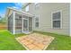 Exterior view of the home featuring a screened porch, green lawn, and stone patio at 1350 Wild Goose Trl, Summerville, SC 29483