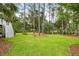 Grassy backyard with tall pines, a white staircase, and a hammock in the background at 1417 S Jetties Ct, Mount Pleasant, SC 29466