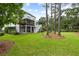 Home's backyard featuring a lawn, trees, stairs to screened porch and covered patio with chairs at 1417 S Jetties Ct, Mount Pleasant, SC 29466