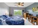 Bedroom with wooden furniture, blue patterned bedding, ceiling fan and a large window with bright sunlight at 1417 S Jetties Ct, Mount Pleasant, SC 29466