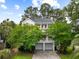 Charming two-story traditional home with a double porch and a two-car garage surrounded by lush greenery at 1417 S Jetties Ct, Mount Pleasant, SC 29466