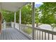 Charming porch with white columns and railings overlooking lush trees and a street view at 1417 S Jetties Ct, Mount Pleasant, SC 29466