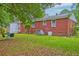 Well-maintained backyard featuring a brick house, lush greenery, and outdoor seating area at 1430 Brian Rd, Charleston, SC 29407