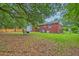 Backyard of home with brick and siding, mature trees and patio furniture on lawn at 1430 Brian Rd, Charleston, SC 29407