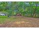Spacious backyard with mature trees, lush greenery and small storage shed at 1430 Brian Rd, Charleston, SC 29407