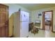 Bright kitchen has white refrigerator, black table, chair, and computer with exterior door at 1430 Brian Rd, Charleston, SC 29407