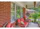 Relaxing front porch seating area with comfortable wicker chairs and bright red cushions at 1430 Brian Rd, Charleston, SC 29407