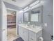 Bathroom featuring double sink vanity with granite countertop, decorative mirrors, and open door view to bedroom at 146 Chaste Tree Cir, Goose Creek, SC 29445