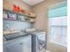 Laundry room featuring a washer, dryer, window, and shelving for storage at 146 Chaste Tree Cir, Goose Creek, SC 29445