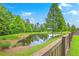 Scenic pond view with mature trees and wooden fence, creating a serene and private backyard setting at 146 Chaste Tree Cir, Goose Creek, SC 29445