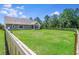 Spacious, fenced backyard with well-manicured lawn and partial view of the home at 148 Hidden Hills Rd, Cross, SC 29436