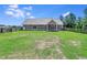 Large, grassy backyard with a gray house, featuring fenced perimeter for privacy at 148 Hidden Hills Rd, Cross, SC 29436