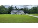 Charming single-story home with well-manicured lawn, inviting porch, and long driveway at 148 Hidden Hills Rd, Cross, SC 29436