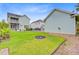 A well-maintained backyard features lush grass and a quaint fire pit, complemented by light-blue siding and black wrought iron fencing at 1485 Bourne Xing, Mount Pleasant, SC 29466