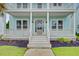 Inviting two-story home with a charming front porch, a neat lawn, and manicured landscaping at 1485 Bourne Xing, Mount Pleasant, SC 29466