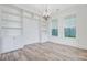 Bright living room features built-in shelving, wood floors, and stylish modern light fixture at 1485 Bourne Xing, Mount Pleasant, SC 29466