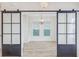 Bright living room showcases sliding barn doors, wood floors, and a modern light fixture at 1485 Bourne Xing, Mount Pleasant, SC 29466