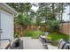 A fenced-in backyard with artificial turf, patio, seating area and landscaping at 1505 Blaze Ln, Charleston, SC 29412