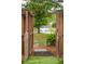 Scenic backyard view through a wooden gate, revealing a tranquil pond with a fountain at 1505 Blaze Ln, Charleston, SC 29412
